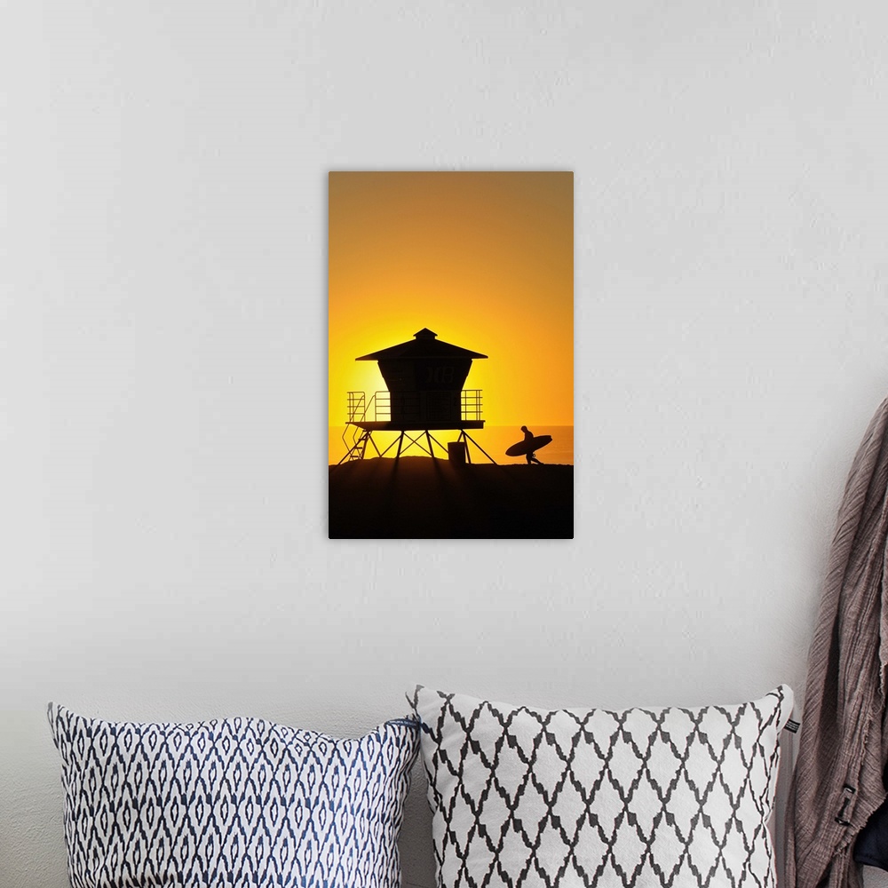 A bohemian room featuring Surfer and Lifeguard tower silhouetted against setting sun.