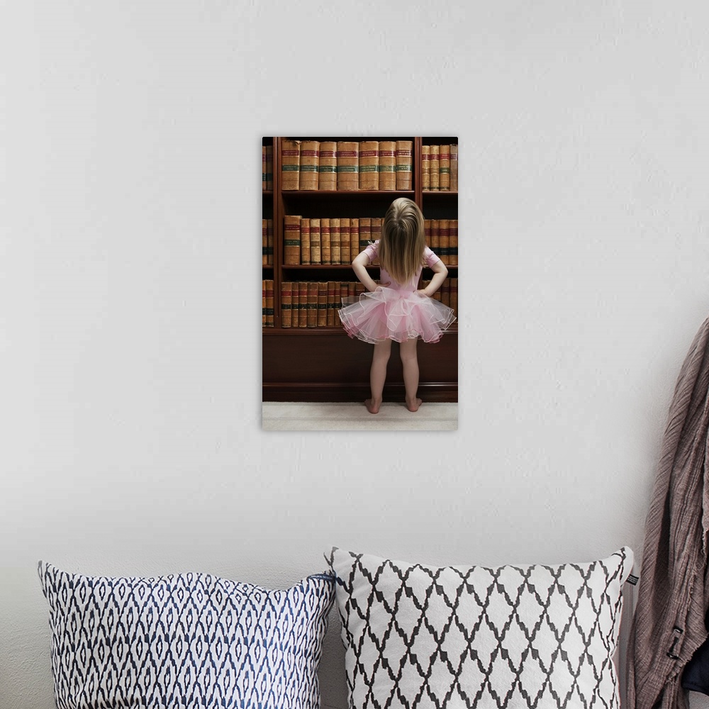 A bohemian room featuring Little girl in tutu reading book covers in library
