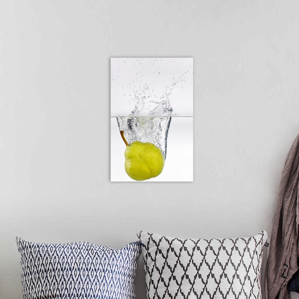 A bohemian room featuring Action photography shot of a ripe pear splashing in to crystal clear water.