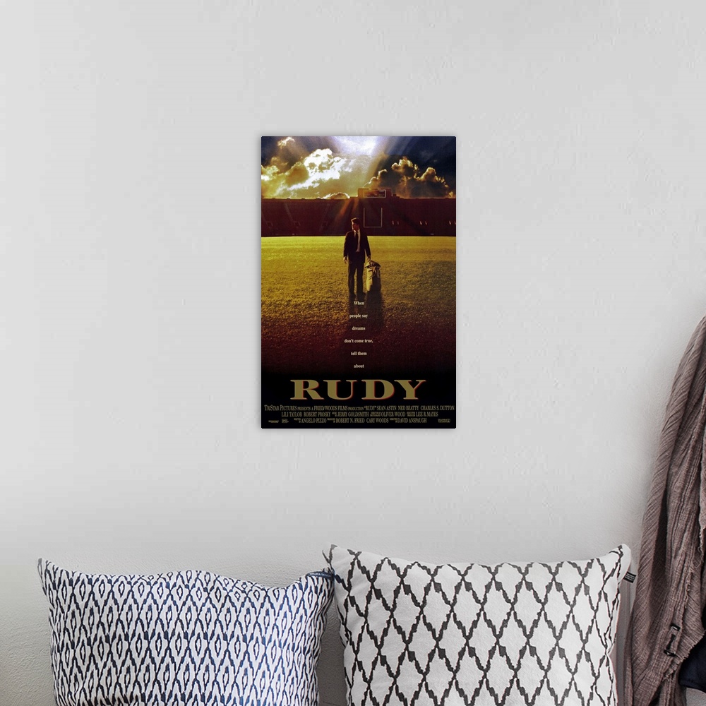 A bohemian room featuring This large vertical piece is a movie poster for "Rudy". It pictures the star character walking ac...