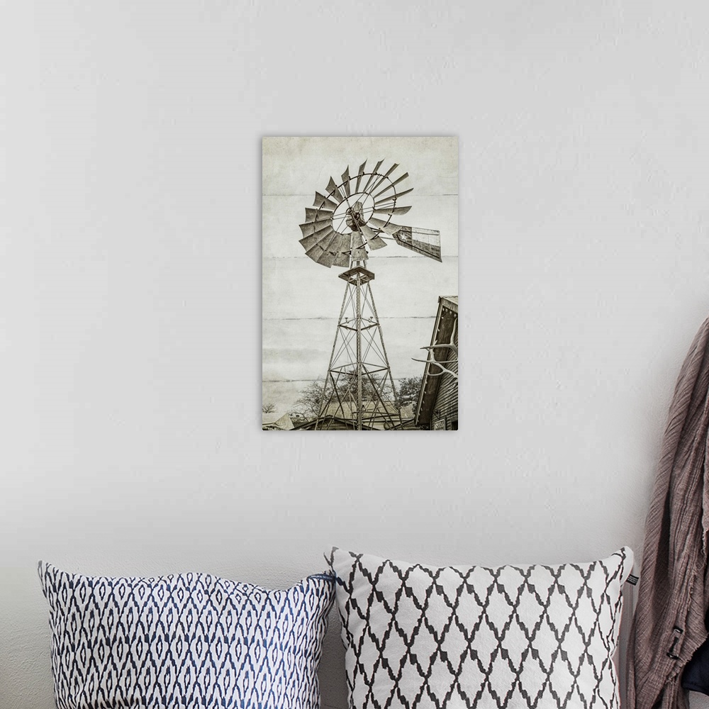 A bohemian room featuring A black and white image of a windmill at a farm with a wood panel effect.
