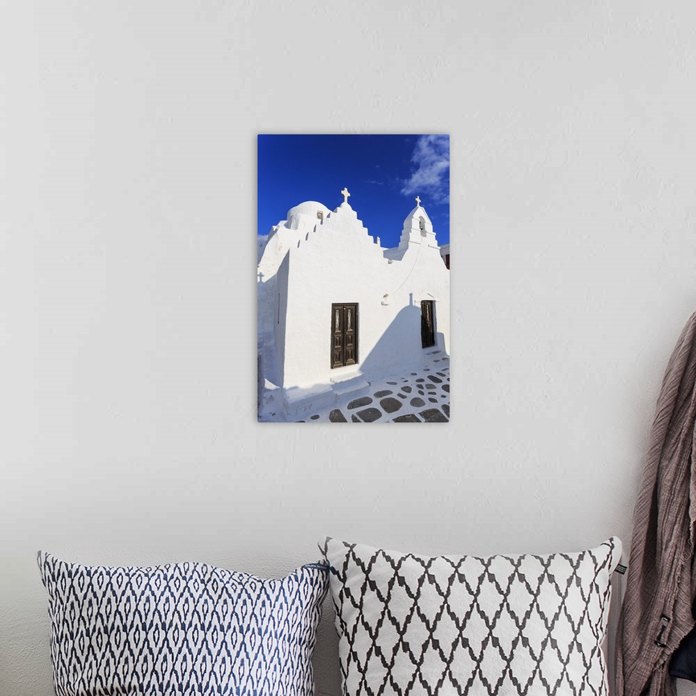 A bohemian room featuring Whitewashed Panagia Paraportiani, Mykonos most famous church, under a blue sky, Mykonos Town, Myk...