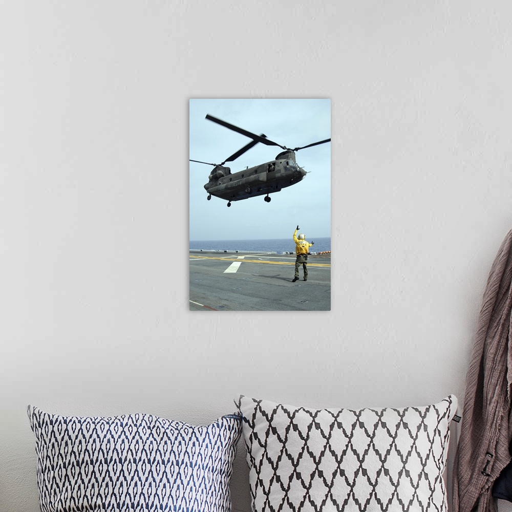 A bohemian room featuring Airman directs an Army CH-47 Chinook helicopter on the flight deck.