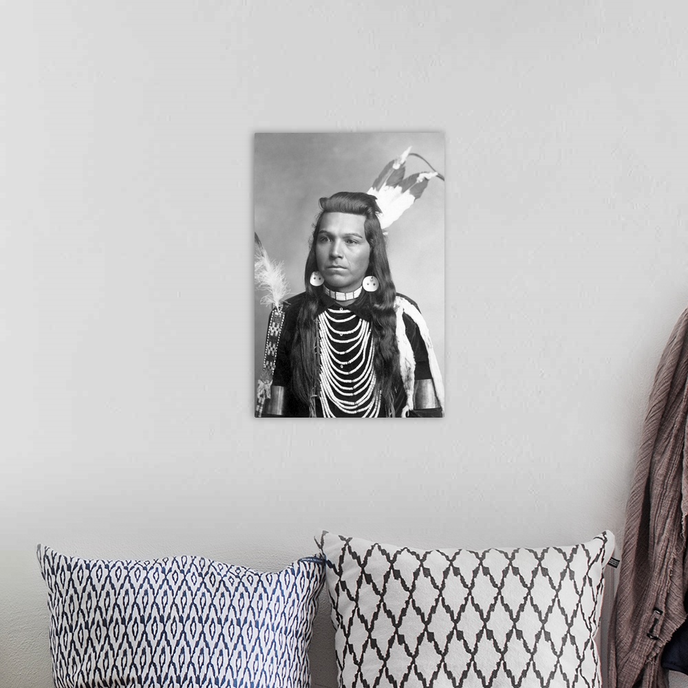 A bohemian room featuring Native American portrait of Joseph Cregg, a man from the Plateau region, wearing necklaces.