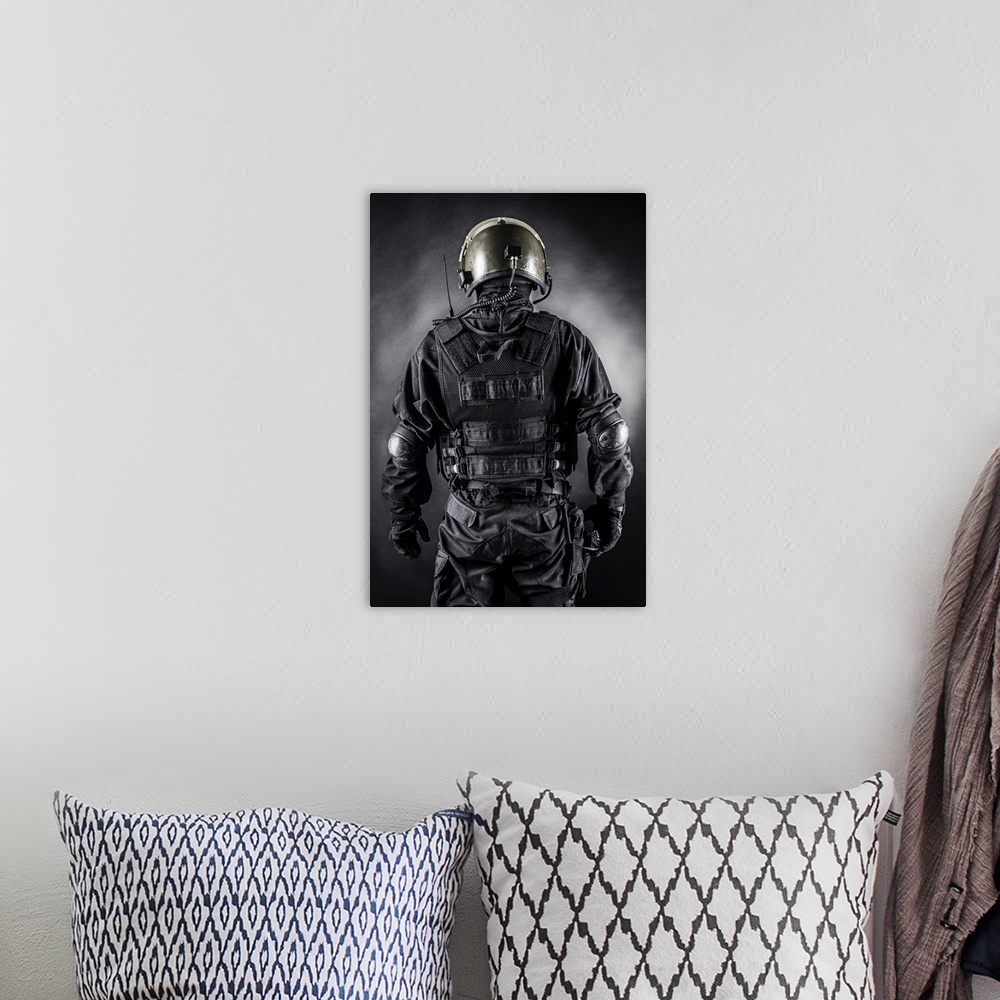 A bohemian room featuring Spec ops soldier on black background shot from behind.