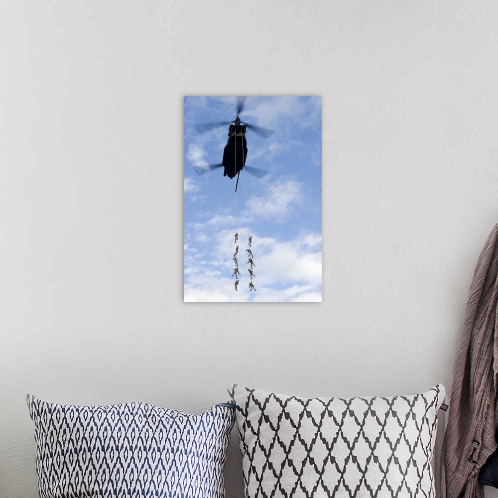A bohemian room featuring U.S. Soldiers are suspended by a CH-47 Chinook helicopter.
