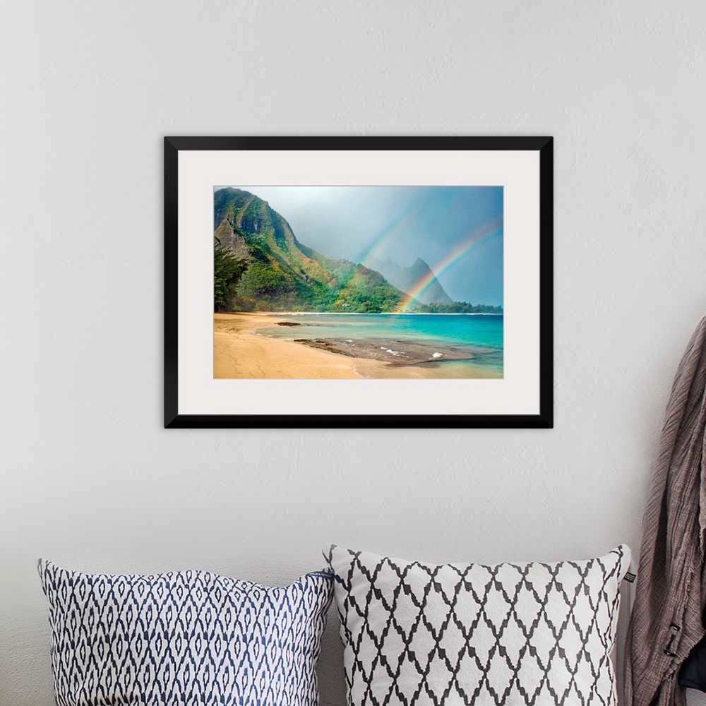 A bohemian room featuring A landscape photograph with double rainbows on a tropical beach with mountains in the background.