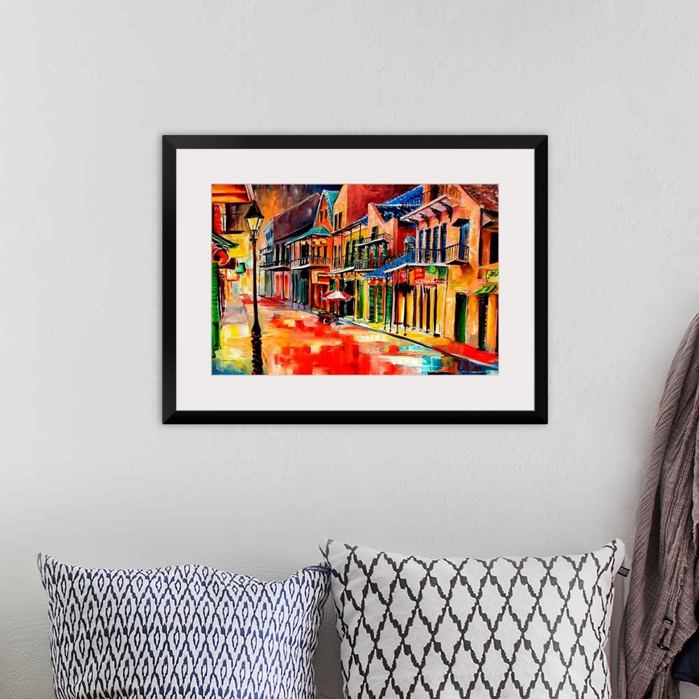 A bohemian room featuring Huge contemporary art shows the vibrantly colored buildings lit up on a quiet street in Louisiana...