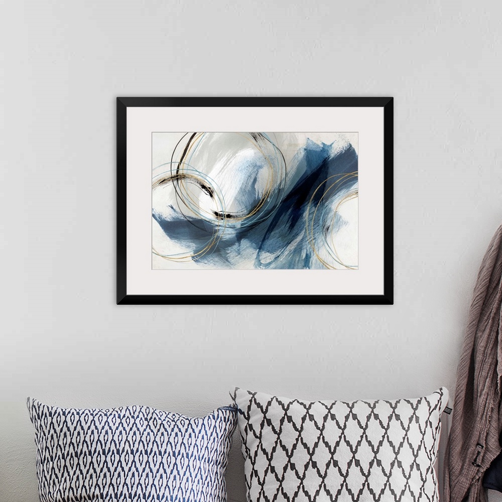 A bohemian room featuring Abstract painting with large blue brushstrokes and circular lines accented with gold.