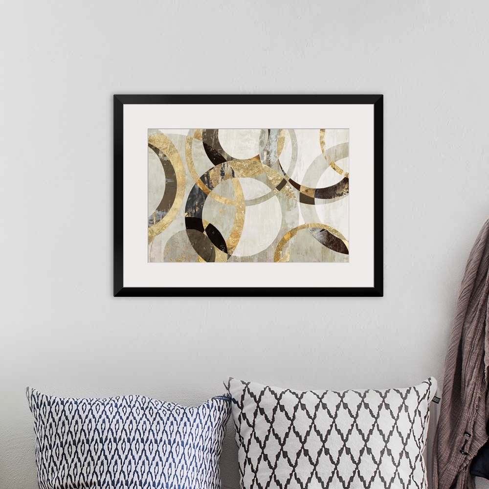 A bohemian room featuring Geometric abstract artwork with circular rings in shades of brown, gold, and gray.