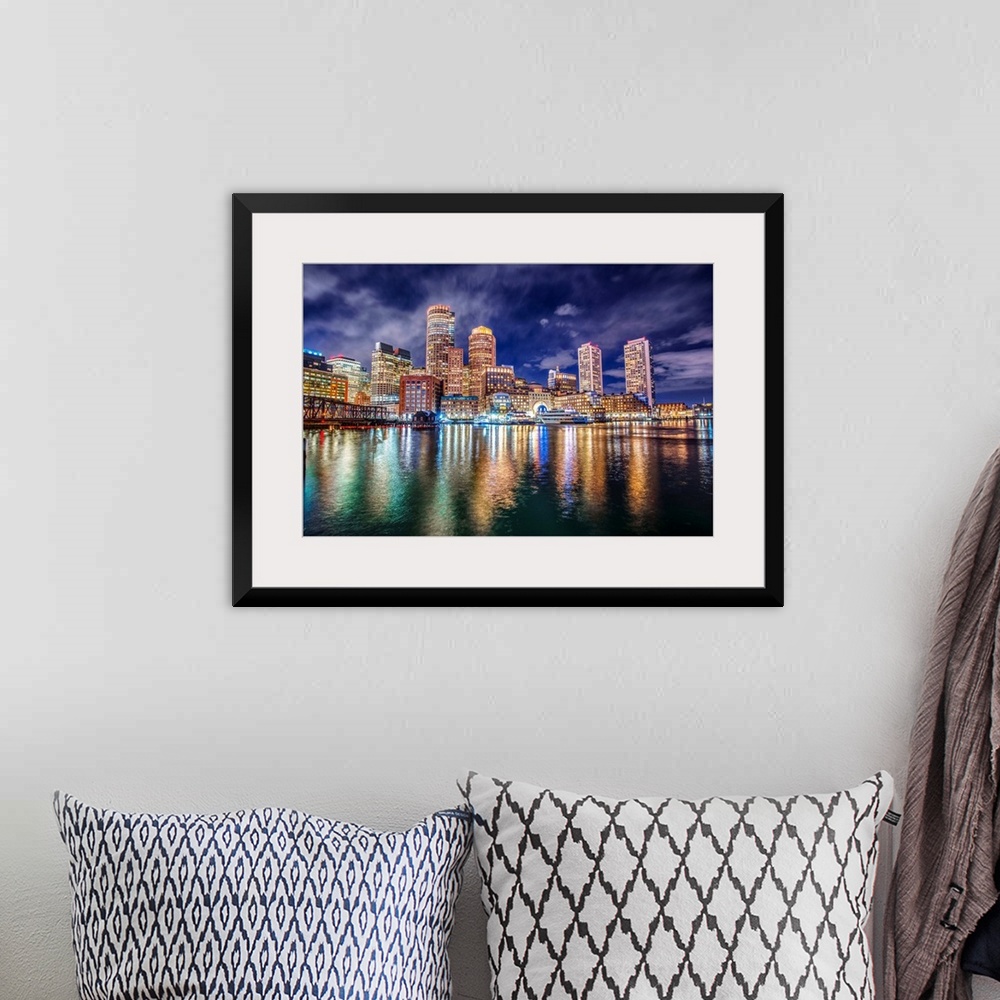 A bohemian room featuring The lights of downtown Boston reflect upon Massachusetts Bay.