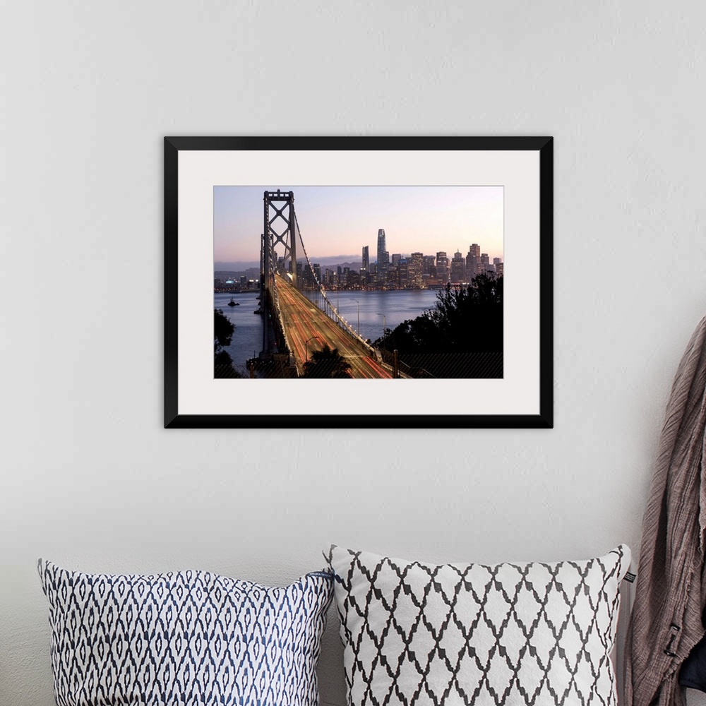 A bohemian room featuring Photograph of the Bay Bridge with a pink and purple sunset and the San Francisco skyline lit up i...