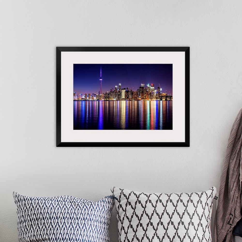 A bohemian room featuring Photo of the Toronto city skyline with lights reflected in the water at night.
