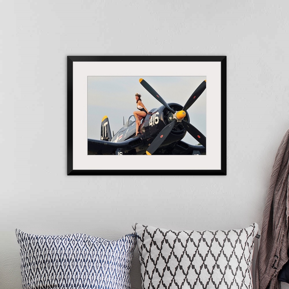 A bohemian room featuring 1940's style Navy pin-up girl sitting on a vintage World War II Corsair fighter plane.