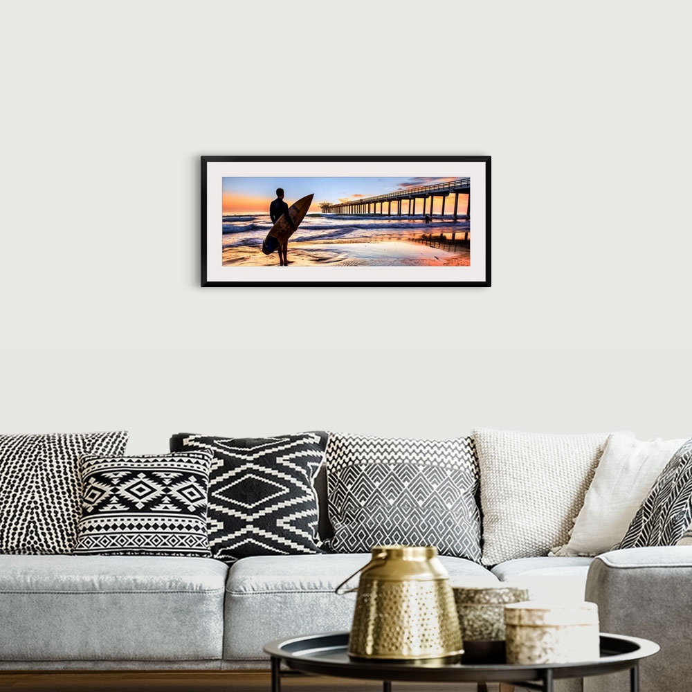 A bohemian room featuring Silhouetted panoramic photograph of a man holding a surf board on the shore of Scripps Beach in S...