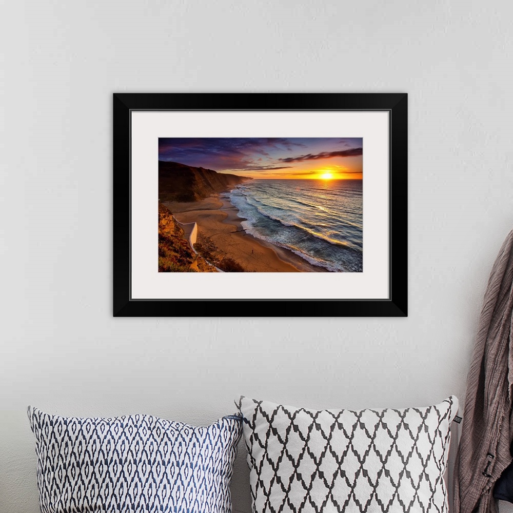 A bohemian room featuring Warm landscape photograph of the sunset in Praia Do Magoito, Portugal.