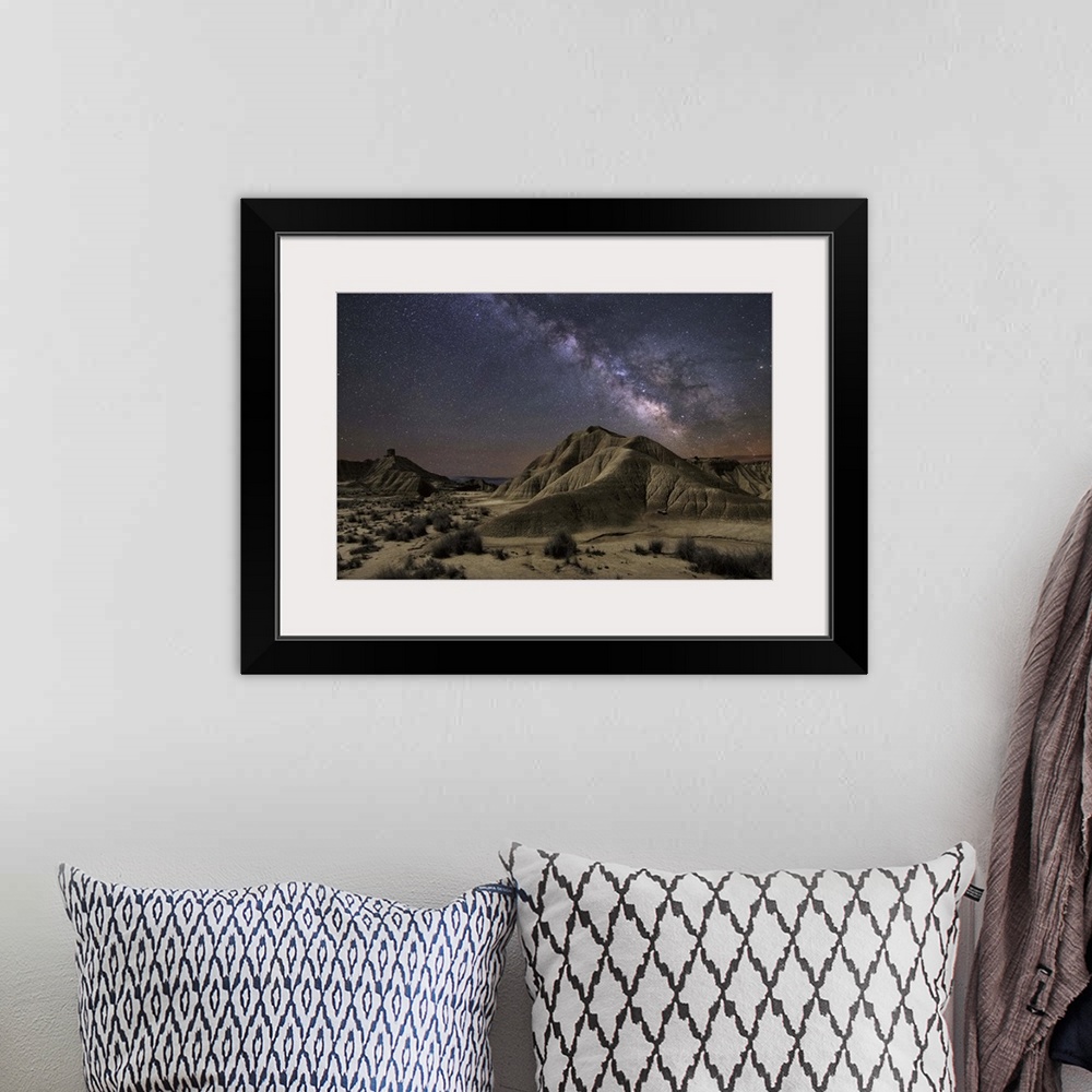 A bohemian room featuring The Milky Way galaxy illuminated over a rocky desert landscape.