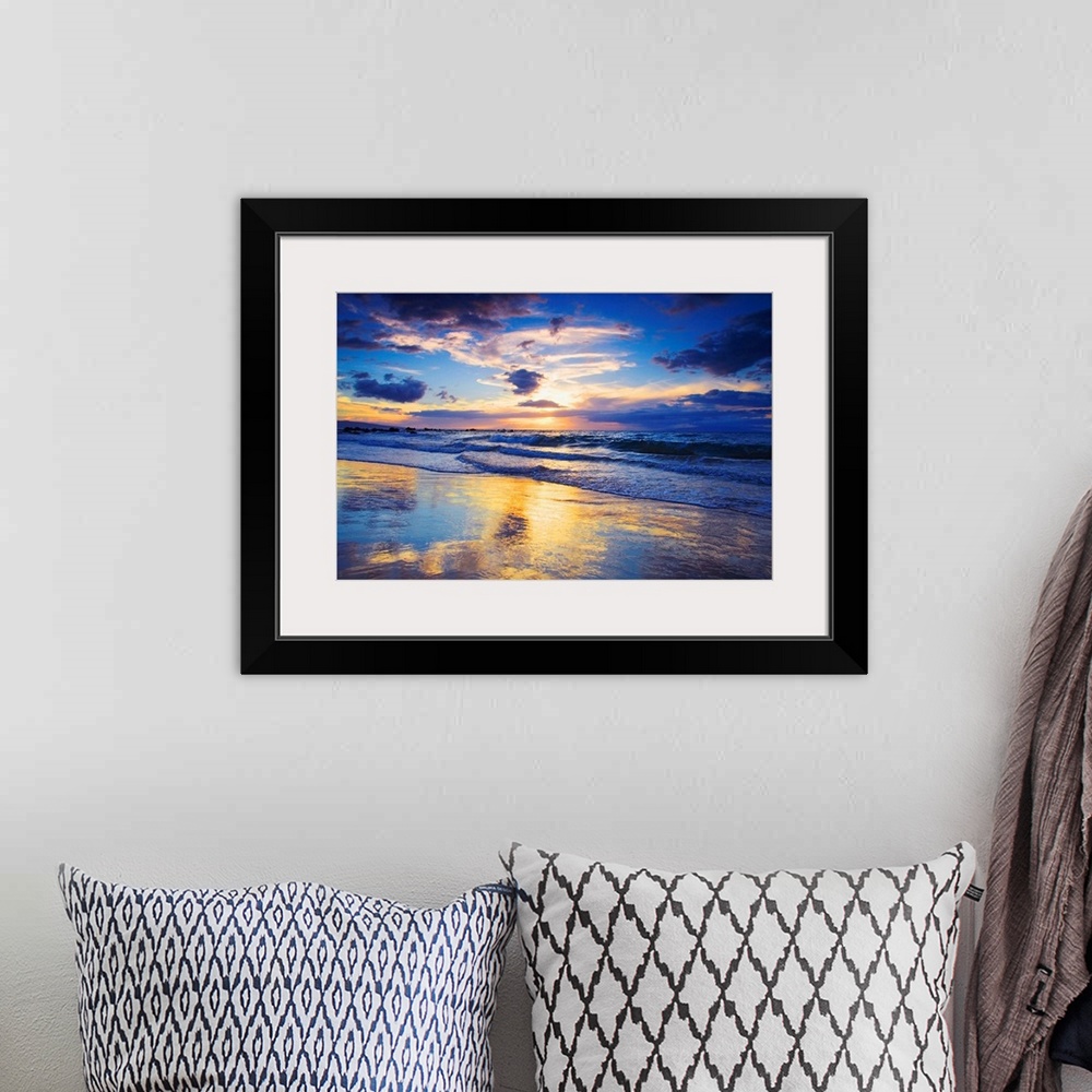 A bohemian room featuring Horizontal photograph on a large wall hanging of a vivid sunset glowing through clouds, over the ...