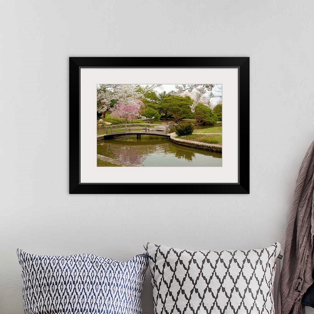 A bohemian room featuring Large canvas photo art of a bridge crossing a river with flowering Japanese trees sprinkled aroun...