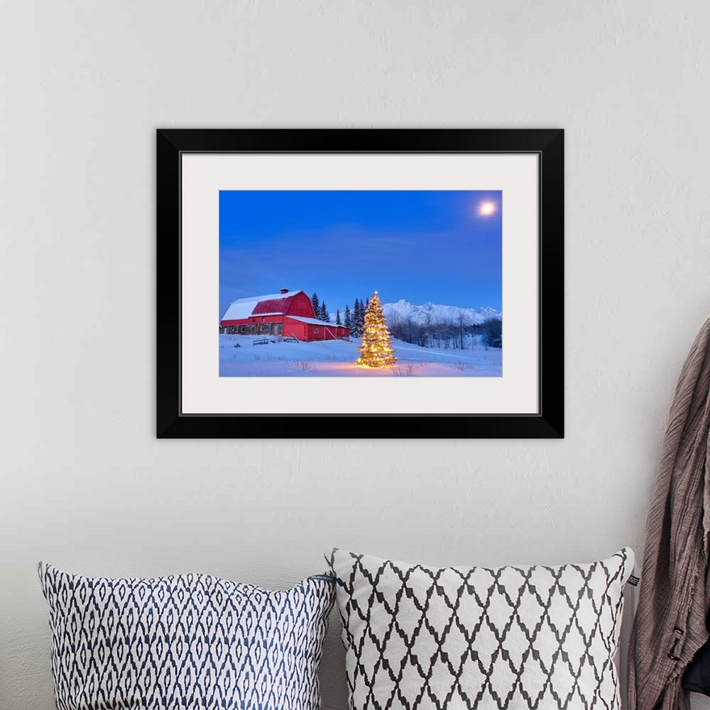 A bohemian room featuring Lit christmas tree in a snow covered field standing in front of a red barn