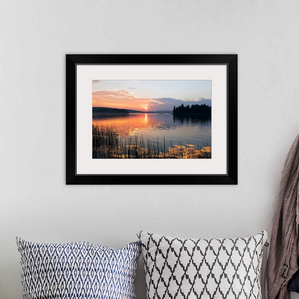 A bohemian room featuring Canvas print of a peaceful lake with a sunset reflected onto it.