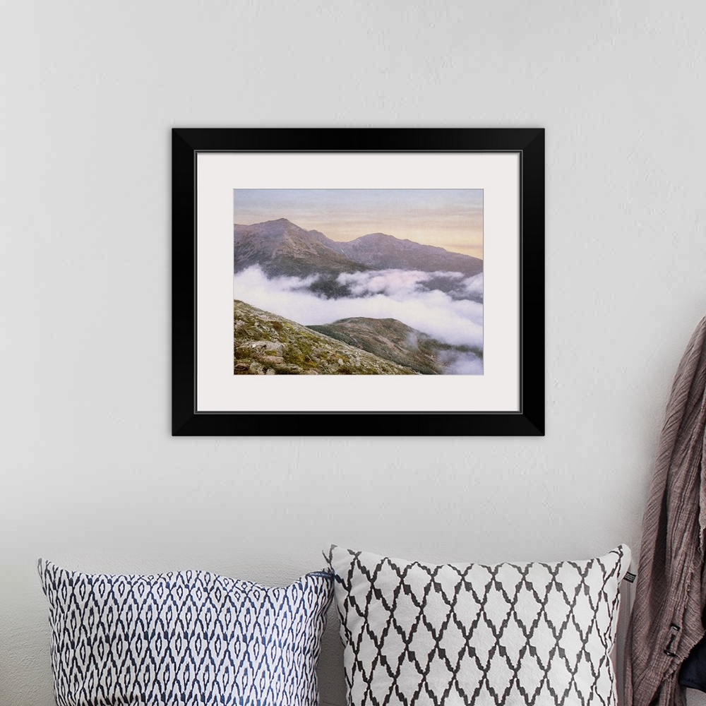A bohemian room featuring Photograph of mountains peeking through fog.