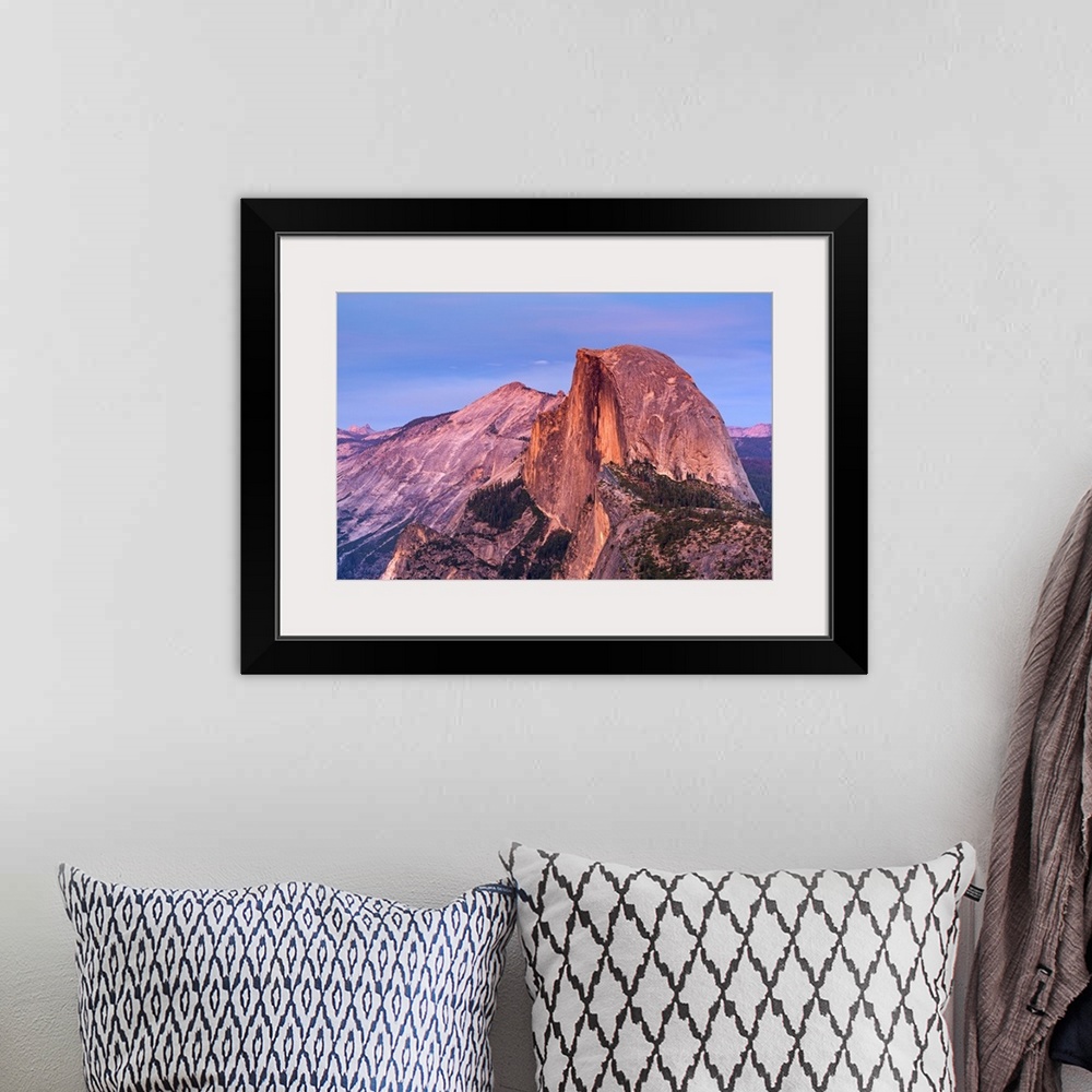 A bohemian room featuring Half Dome in Yosemite bathed in pink light from the sunset.