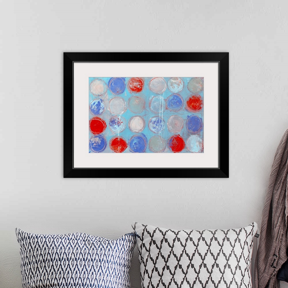 A bohemian room featuring A contemporary abstract painting of colorful circles against a pale blue background.
