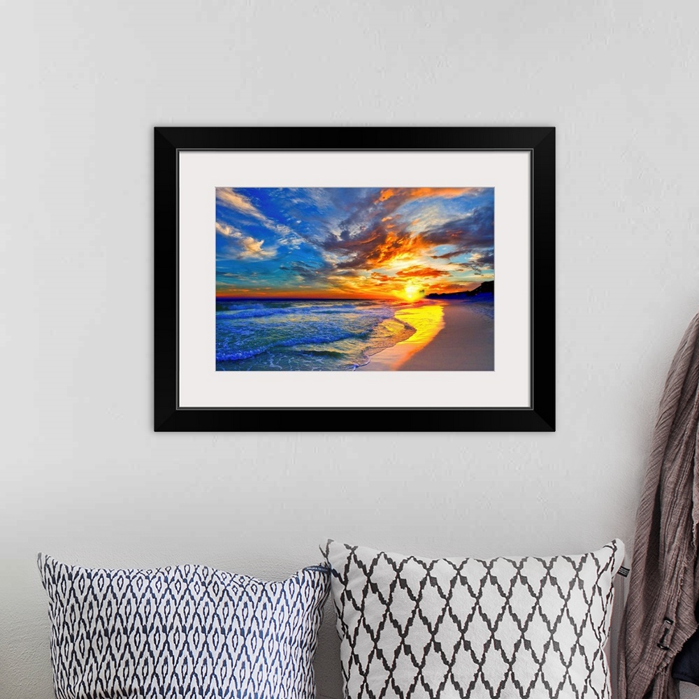 A bohemian room featuring An amazing sunset with red and blue sky and clouds. A blue seascape and beach below.