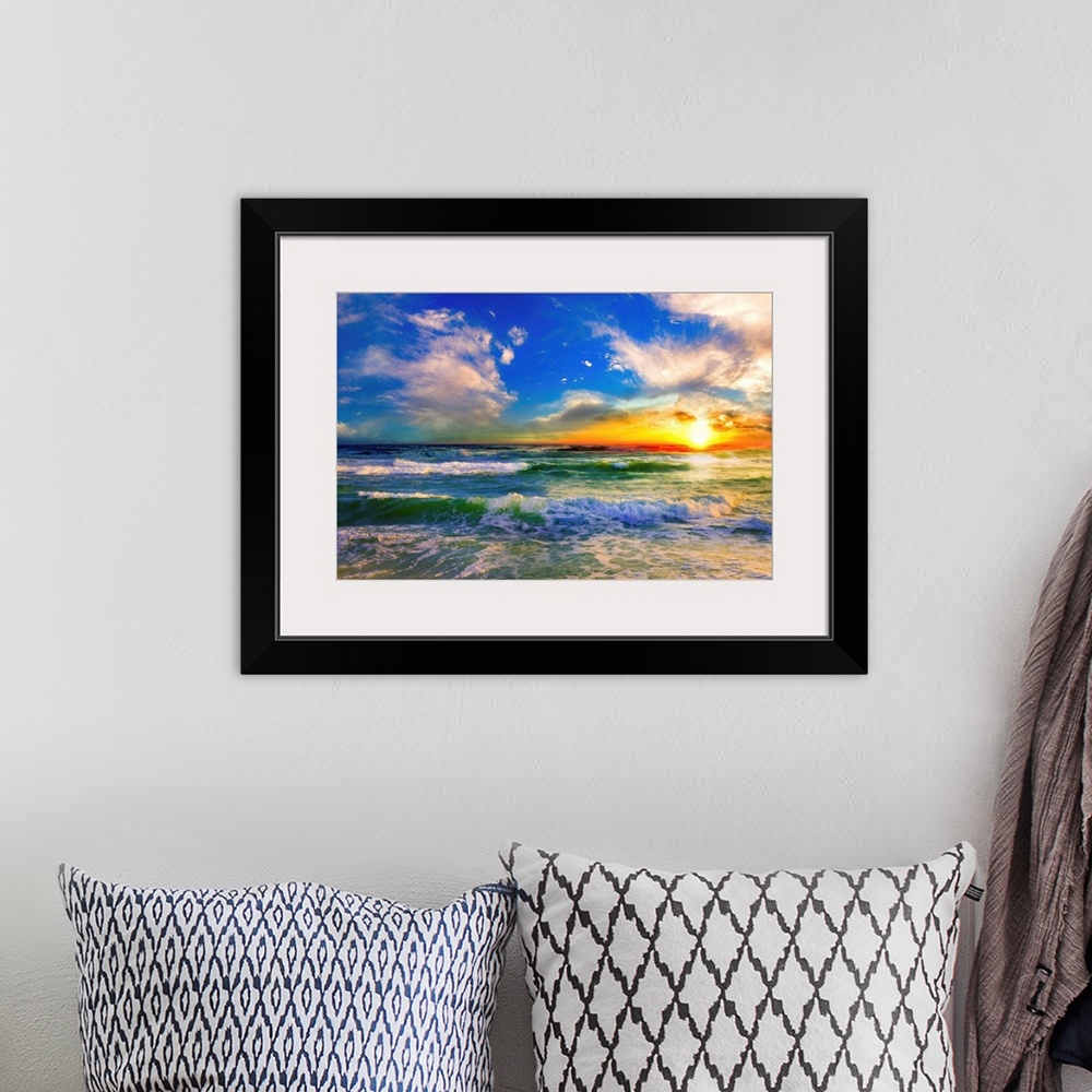 A bohemian room featuring A blue ocean sunrise with white crested waves. A colorful seascape sunset with an orange sun.