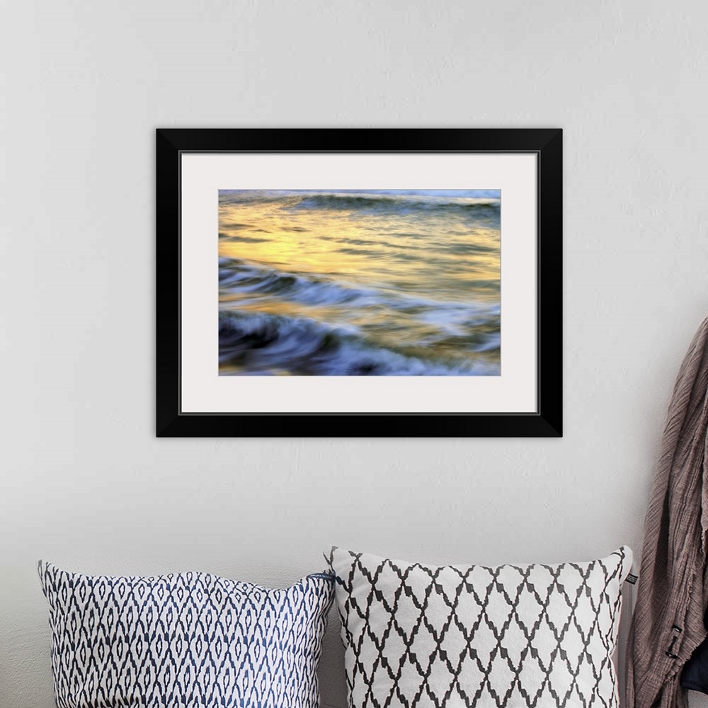 A bohemian room featuring Soft photograph of a sunset reflecting light on the ocean waves.