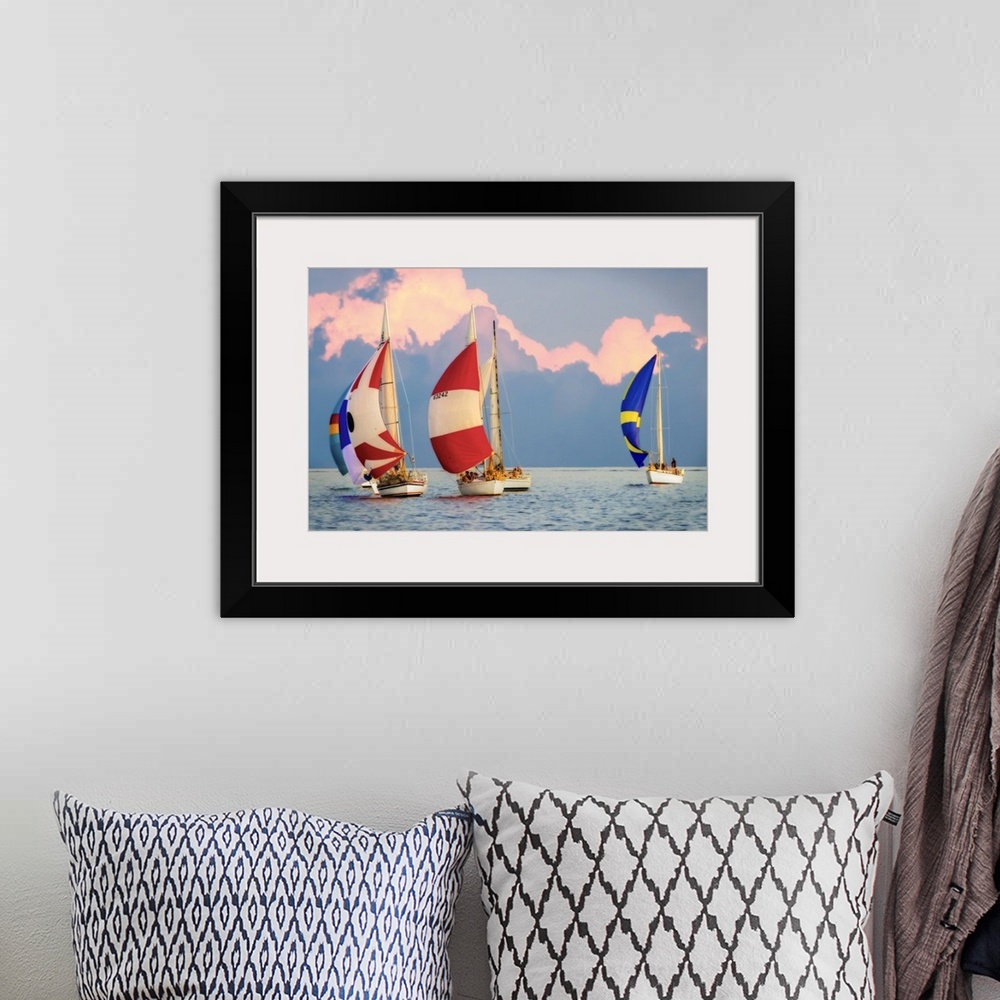 A bohemian room featuring Sailboats with colorful sails on the water with large clouds in the sky.