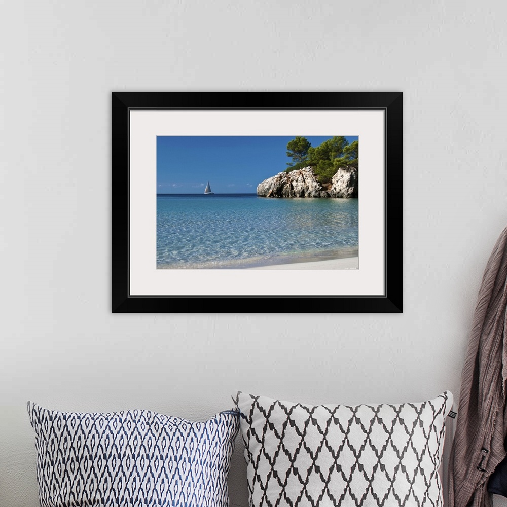 A bohemian room featuring Photo of crystal clear blue water and white sand beach in Spain with a sailboat in the distance a...