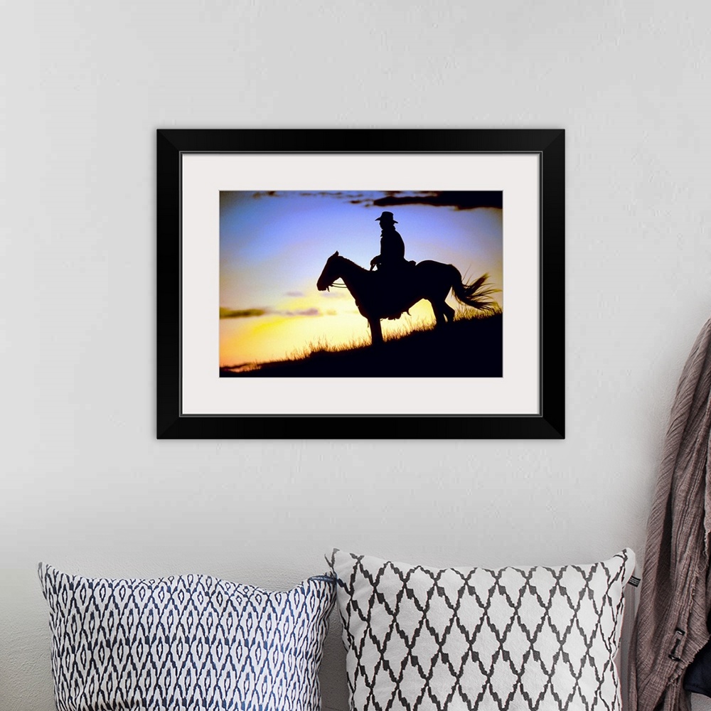 A bohemian room featuring A lone figure and his steed on a hillside was the light fades around them in this landscape photo...