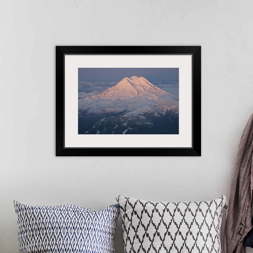 A bohemian room featuring Landscape, aerial photograph of a snow covered Mount Rainier, surrounded by clouds, a dark sky in...