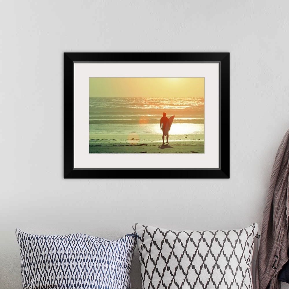 A bohemian room featuring Big print on canvas of a surfer with a surfboard silhouetted against the setting sun looking out ...