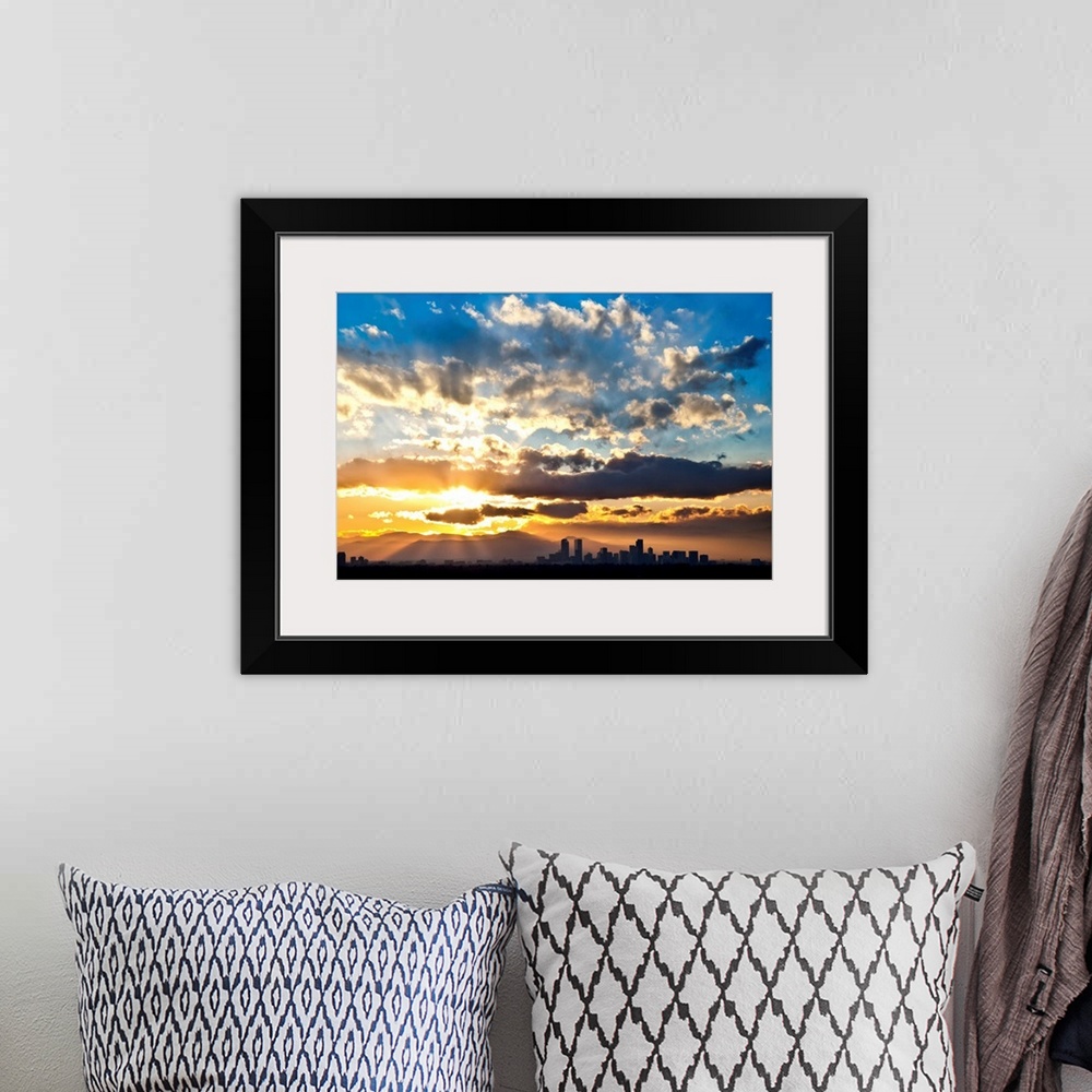 A bohemian room featuring Large photograph focuses on the sun's powerful rays trying to break through a sky scattered with ...
