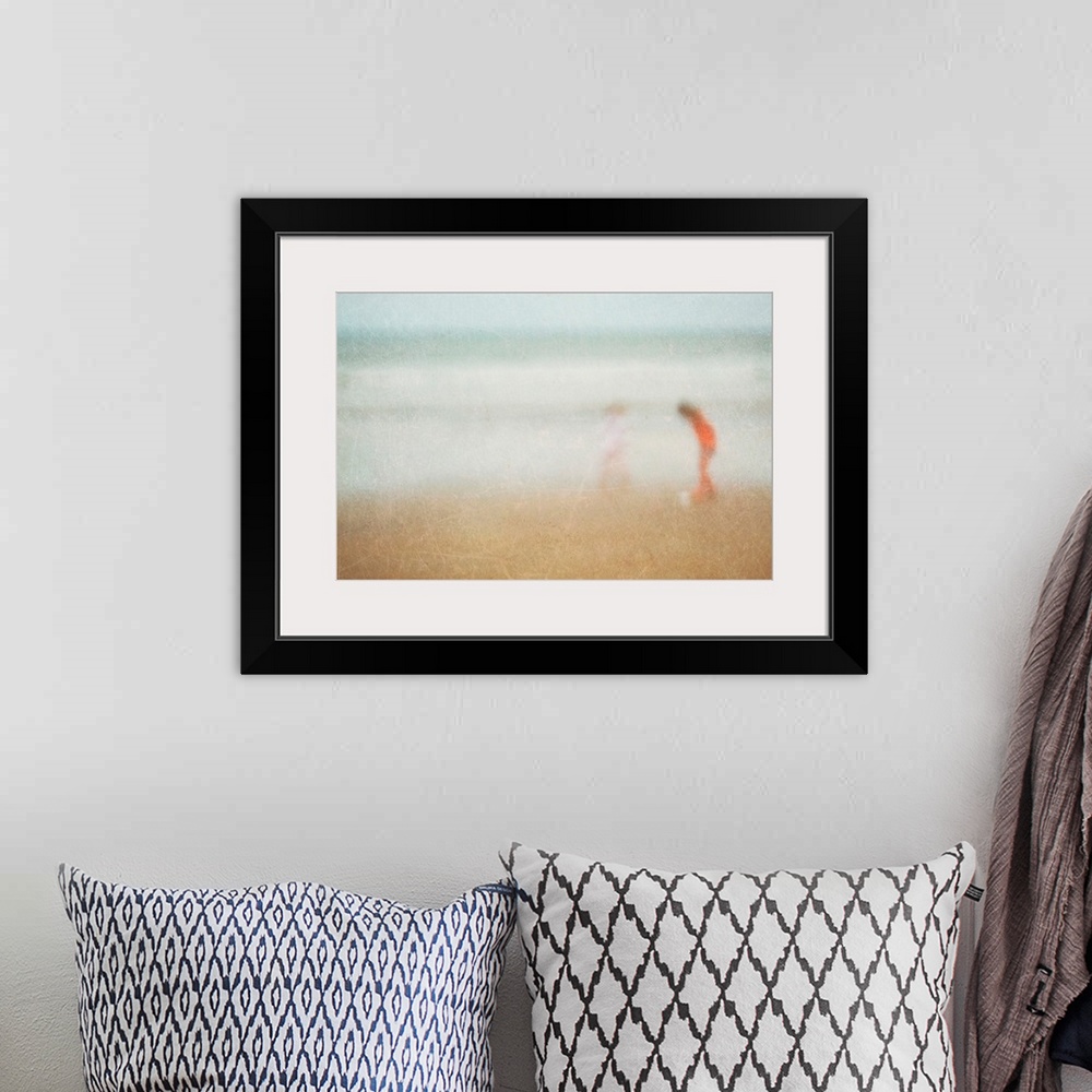 A bohemian room featuring Giant photograph shows two children playing on a sandy beach at the edge of an ocean.  Photograph...
