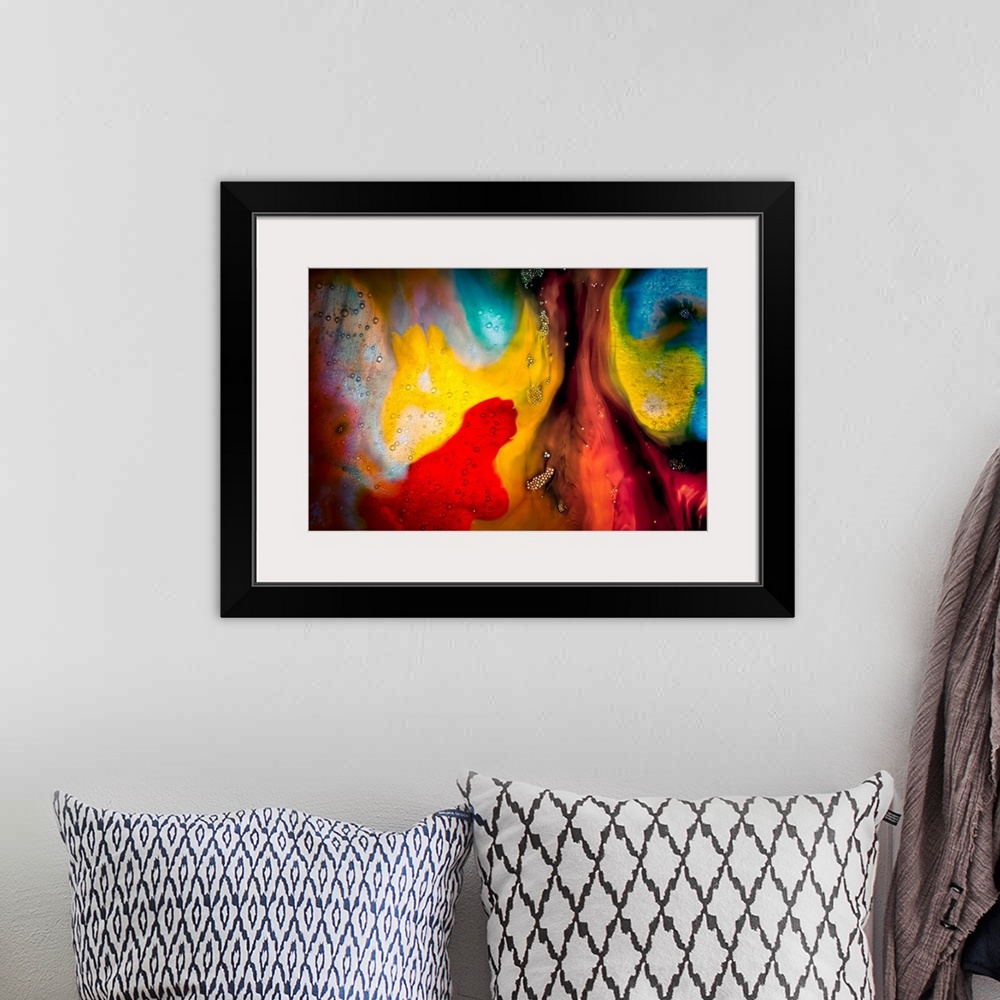 A bohemian room featuring Fine art abstract photograph of swirling paint in bright reds and yellows.