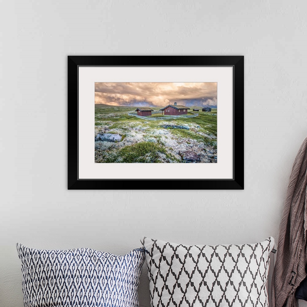 A bohemian room featuring A photograph of a Norwegian landscape with post storm clouds hanging overhead.