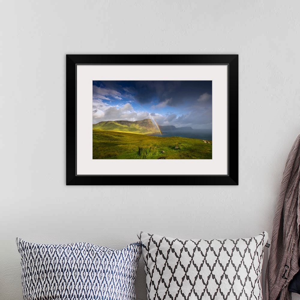 A bohemian room featuring Fine art photo of lush green cliffs at the edge of the sea under a dramatic sky.
