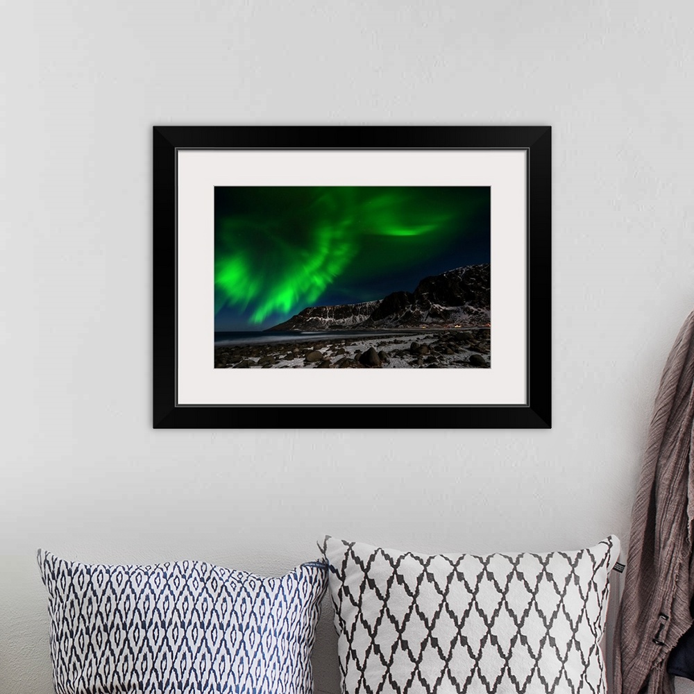 A bohemian room featuring A photograph of the northern lights seen above a rugged winter landscape.