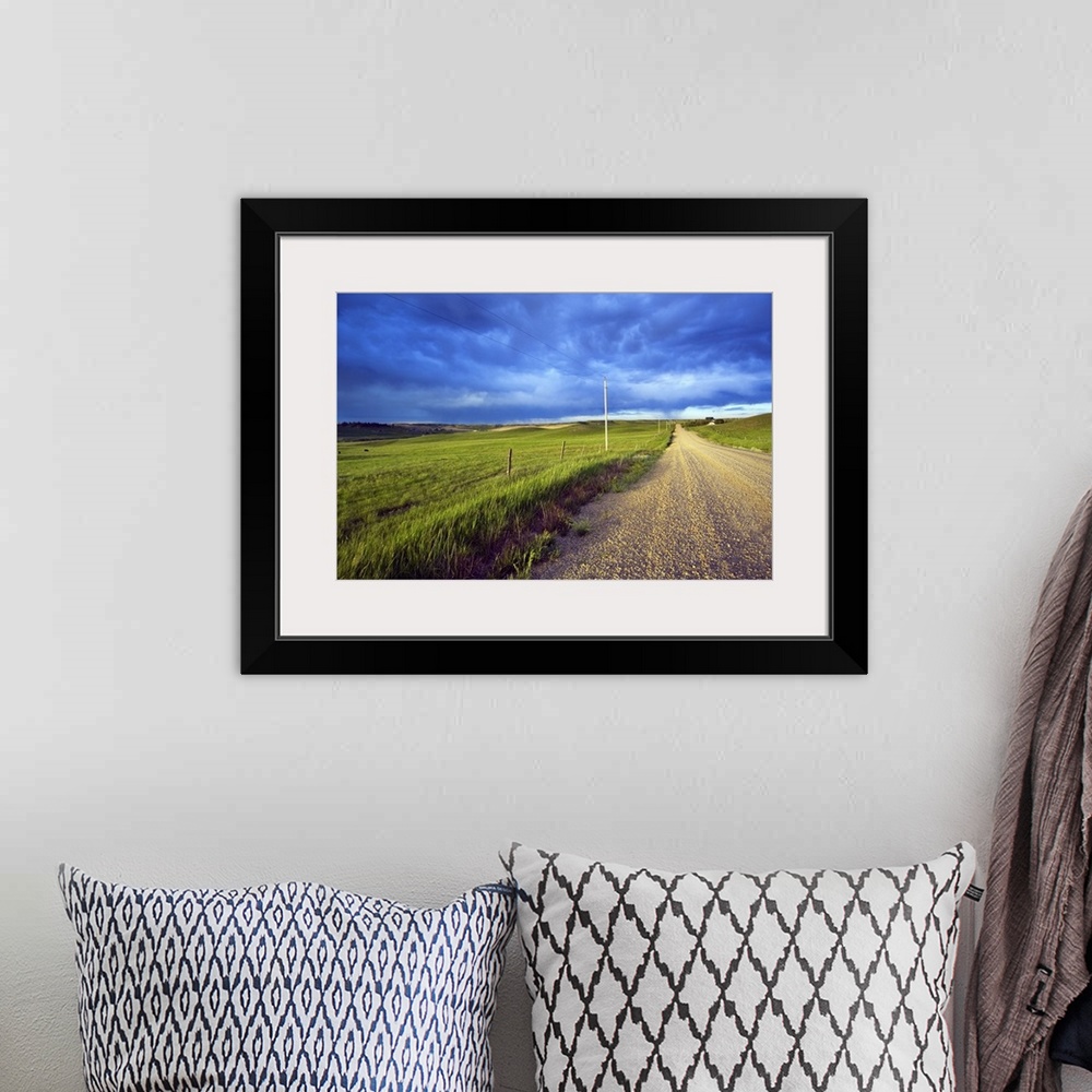 A bohemian room featuring Landscape, oversized photograph of a gravel road, open fields on wither side, beneath a stormy sk...