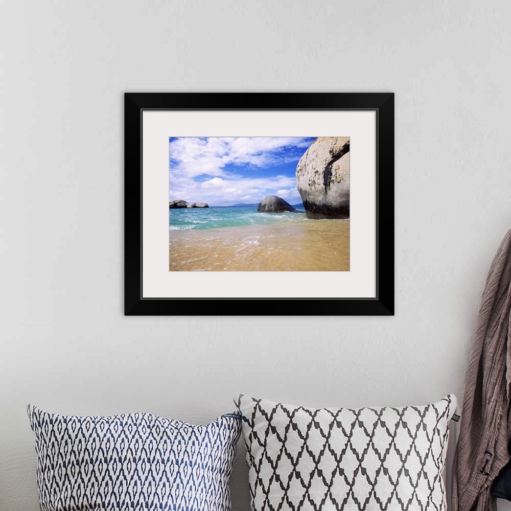 A bohemian room featuring This landscape photograph taken at ground level shows waves rocking against the sandy shore and l...