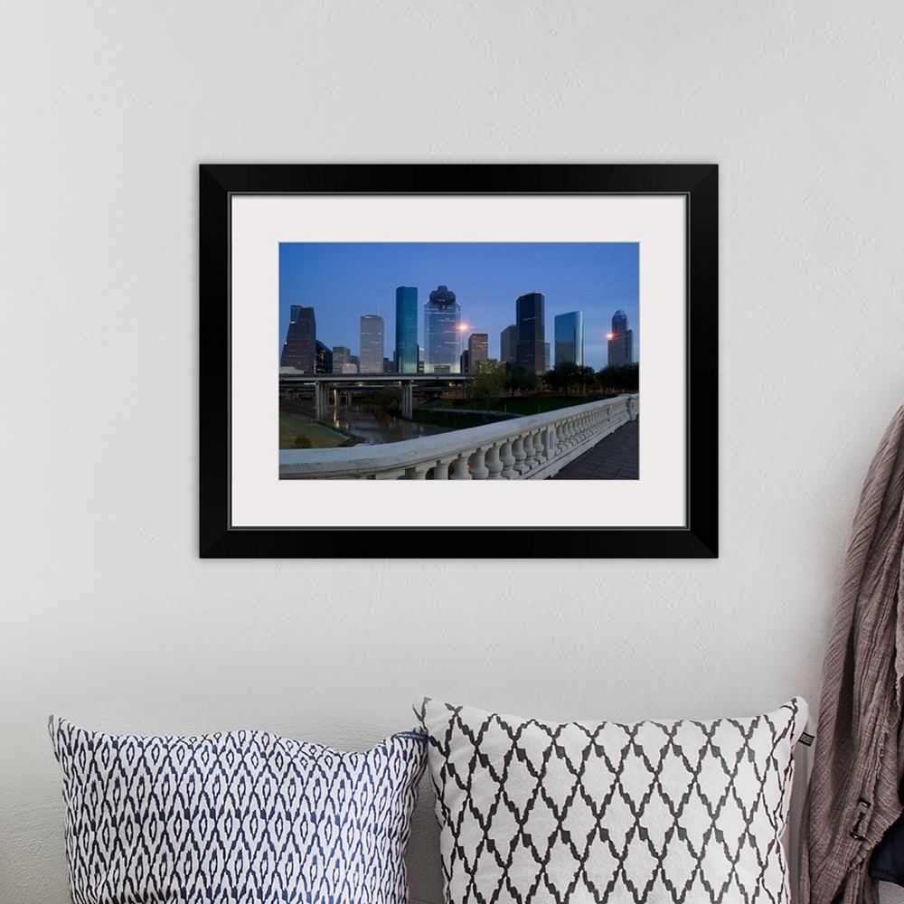 A bohemian room featuring Street view photograph of tall buildings lit up in a city at dusk.