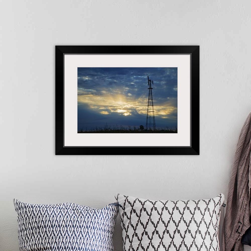 A bohemian room featuring Sunset light through heavy clouds, silhouetted windmill, Iowa