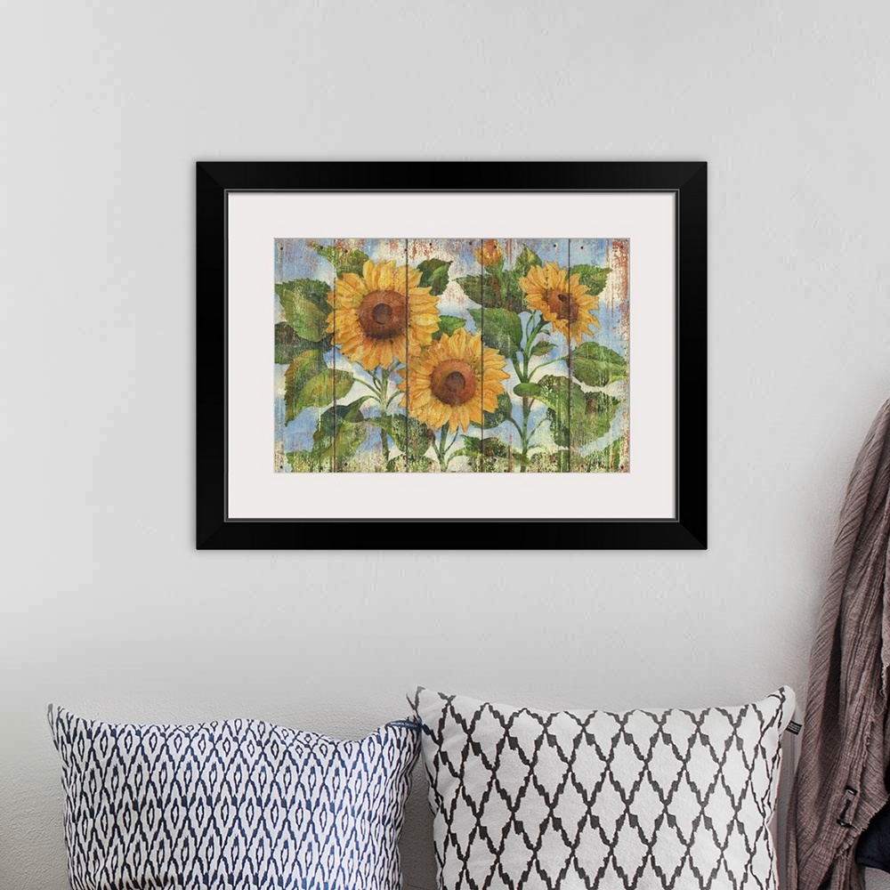 A bohemian room featuring Contemporary decorative artwork of three large sunflowers in full bloom on a textured panel backg...