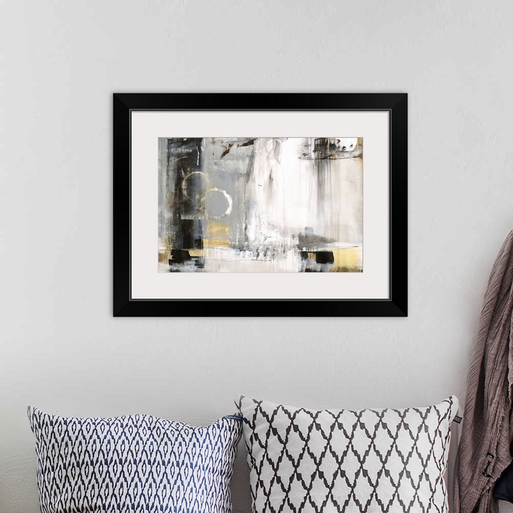 A bohemian room featuring Large abstract painting with white and gray hues on the background and black, brown, and yellow h...