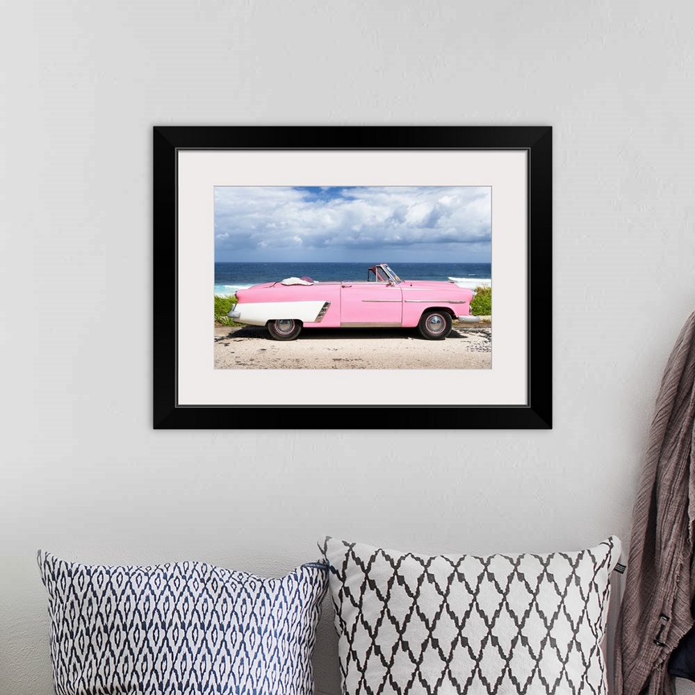 A bohemian room featuring Photograph of a light pink and white vintage convertible parked in front of the ocean.