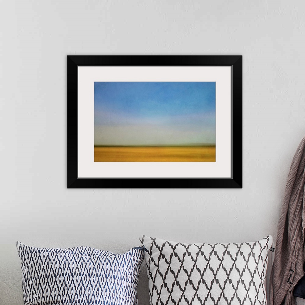 A bohemian room featuring Impressionist landscape of a prairie farm field and blue sky.